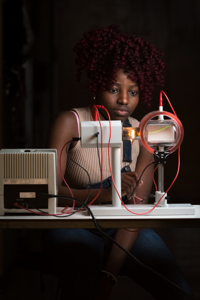An African American woman student working with lab equipment